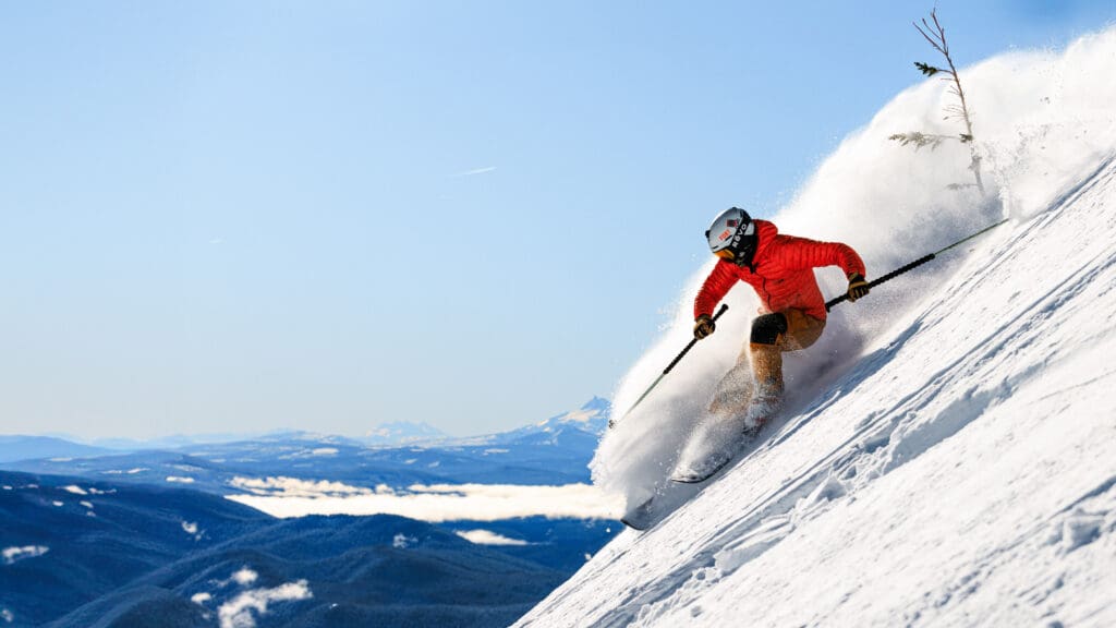 a skier in a red jacket takes on a dramatically steep run showcasing the guide to ski construction