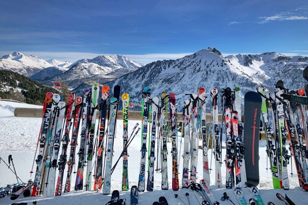 Montgenèvre, France - December 2018: A line of skis and snowboards stored on racks outside a cafe. Ski Resort in the Hautes Alpes buy or rent skis