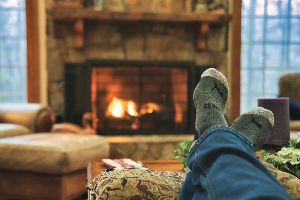 stocking feet propped up in front of a roaring fire