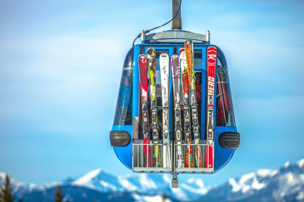 several sets of skis propped against a gondola in motion ski trip packing list featured image