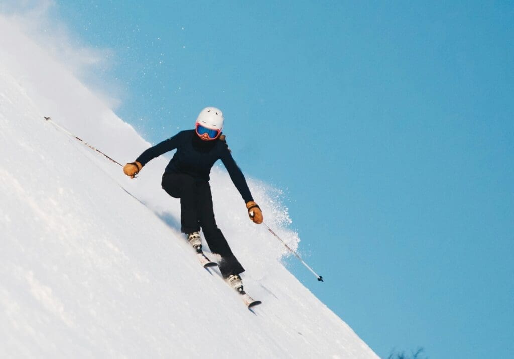 a skiier shredding down a steep hill