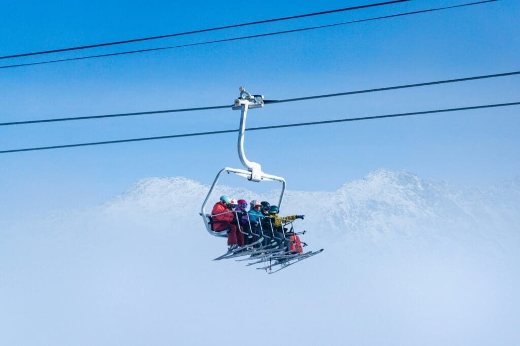 a group of skiers riding on a lift