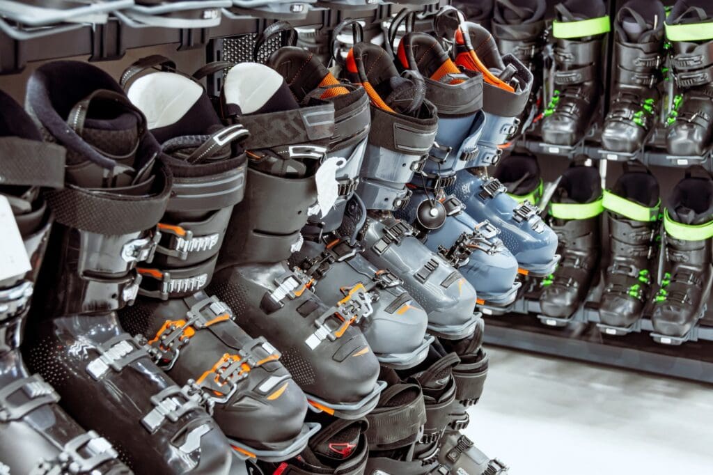 Row of different ski boots in a sports store, shelves view